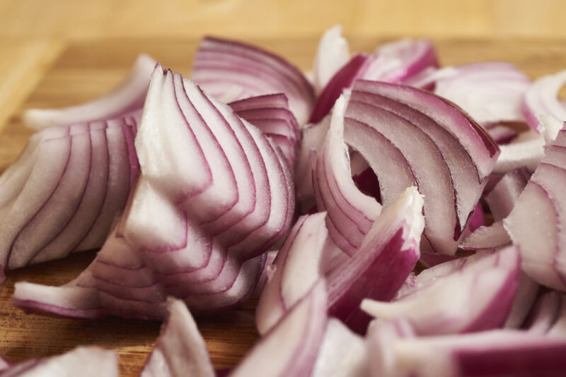 sliced red onions on cutting board