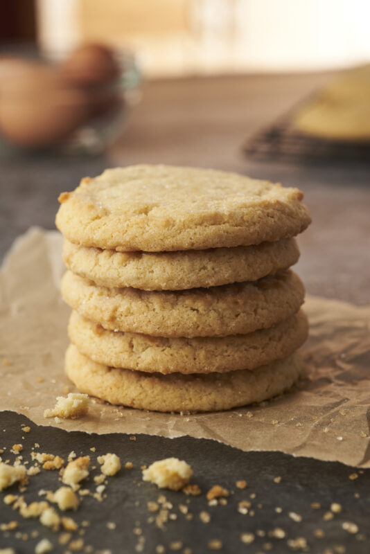 a stack of five sugar cookies on parchment paper